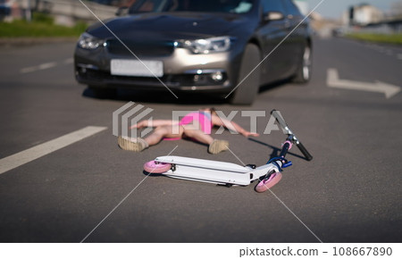 Girl lies on pavement after collision with cars on scooter 108667890