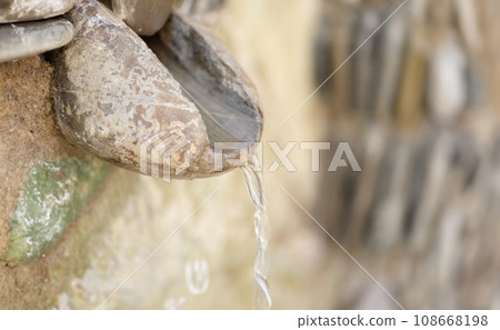 Jet of water flowing from stoneless mountain spring closeup 108668198