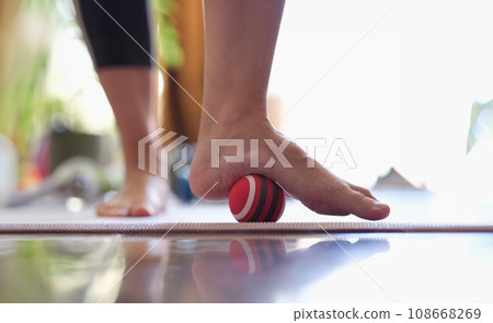 Man massages feet with small ball closeup Man massages feet with small ball closeup 108668269