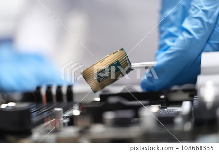 Engineer is holding microprocessor tweezers from motherboard Engineer is holding microprocessor tweezers from motherboard 108668335