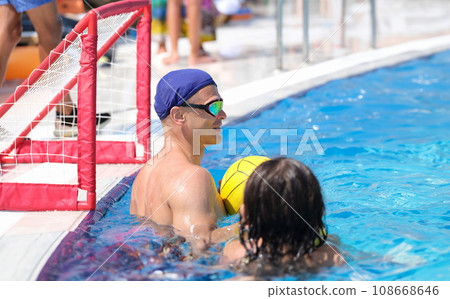 Man at gate in pool plays water polo. 108668646