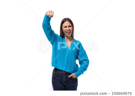 young well-groomed brunette woman dressed in a blue cardigan on a white background with copy space 108669078