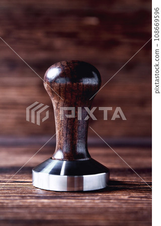 temper coffee beans on a brown wooden background blur 108669596