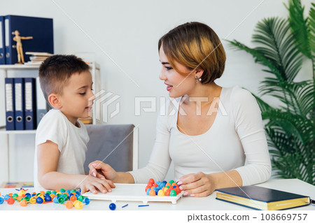 a boy with a female psychologist in the office plays educational games 108669757