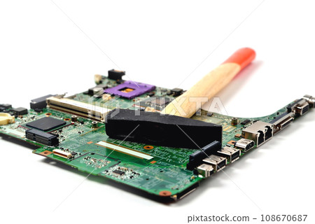 The hammer lies on the old chip from the laptop The hammer lies on the old chip from the laptop 108670687