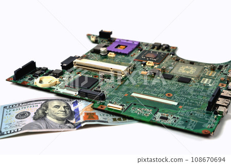 An old chip from a laptop lies on a bill of one hundred dollars, a white background 108670694