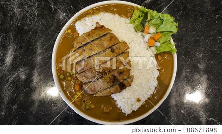 English chicken schnitzel curry with rice and good plating presentation. Thin slice of meat chicken breasts that is breaded and fried, popular dish in Germany. English chicken schnitzel curry with rice and good plating presentation. Thin slice of meat chicken breasts that is breaded and fried, popular dish in Germany. 108671898