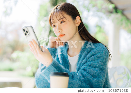 在露台上看智慧型手機的女人 108671988