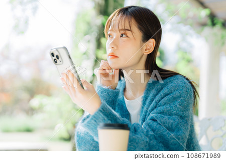 在露台上看智慧型手機的女人 108671989