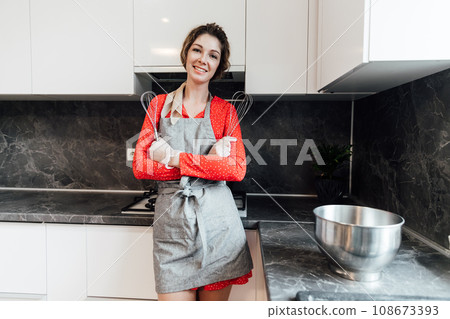 woman cook stands in kitchen interior furniture cooking 108673393