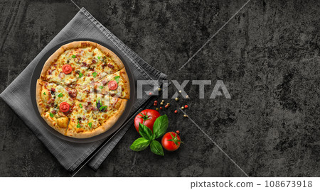 Hot supreme pizza served on black stone with tomatoes and basil flat lay. 108673918