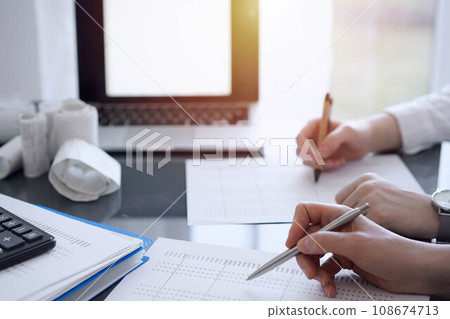 Two accountants use a laptop computer for counting taxes or revenue balance. Business, audit, and taxes concepts 108674713