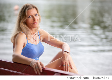 Mature woman in a swimsuit is sunbathing on the beach. Mature woman in a swimsuit is sunbathing on the beach. 108675167