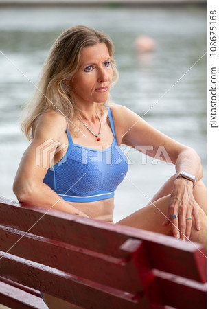 Mature woman in a swimsuit is sunbathing on the beach. Mature woman in a swimsuit is sunbathing on the beach. 108675168