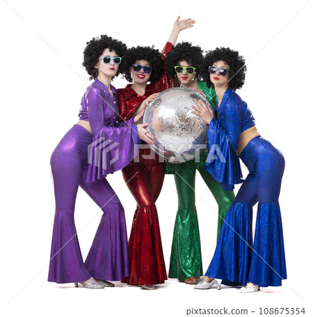 A group of girls in disco costumes are holding a disco ball and looking at the camera. A group of girls in disco costumes are holding a disco ball and looking at the camera. 108675354