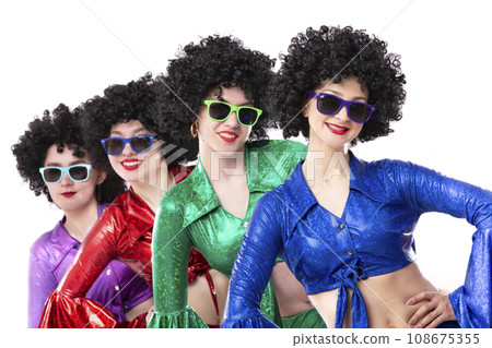 A group of girls in disco style and African wigs in colorful costumes on a white background. Singers and dancers of the eighties and seventies. 108675355
