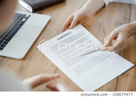 Businesswoman lawyer pointing into contract special points admitting something for colleague or client at the wooden desk in office. Business people teamwork and partnership, meeting concept Businesswoman lawyer pointing into contract special points admitting something for colleague or client at the wooden desk in office. Business people teamwork and partnership, meeting concept 108675477