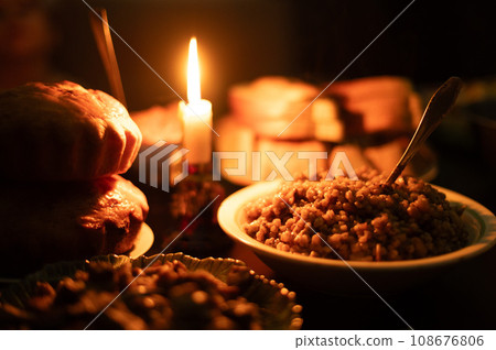 Christmas Eve in a Ukrainian family. Kutya on the table and a lighted candle. Christmas Eve in a Ukrainian family. Kutya on the table and a lighted candle. 108676806