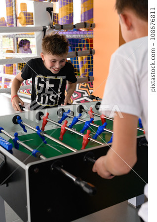 Two boys are playing table football in the playroom 108676811