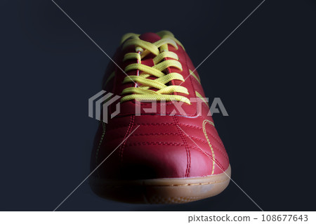 Red sneaker on a black background. Sport shoes 108677643