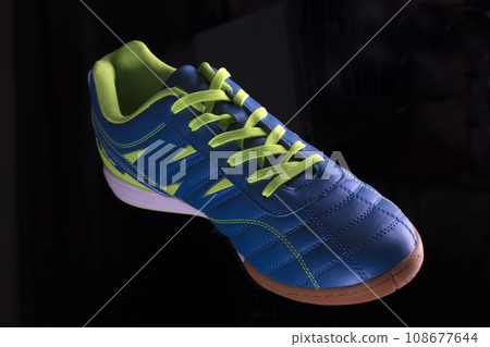 Blue sneakers with green stripes on a black background. Sport shoes. Blue sneakers with green stripes on a black background. Sport shoes. 108677644