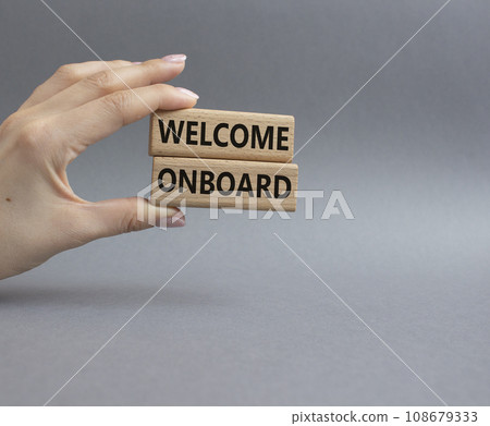 Welcome onboard symbol. Concept words Welcome onboard on wooden blocks. Beautiful grey background. Businessman hand. Business and Welcome onboard concept. Copy space. 108679333
