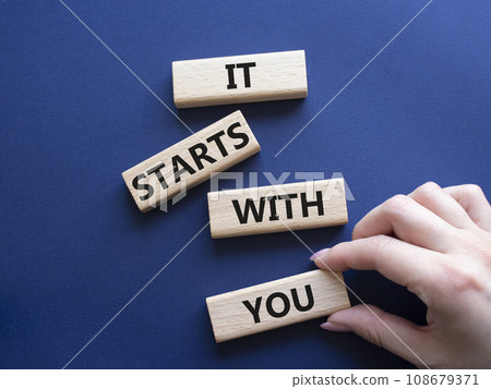 It starts with you symbol. Wooden blocks with words It starts with you. Beautiful deep blue background. Businessman hand. Business and It starts with you concept. Copy space. It starts with you symbol. Wooden blocks with words It starts with you. Beautiful deep blue background. Businessman hand. Business and It starts with you concept. Copy space. 108679371