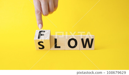Flow and Slow symbol. Businessman points at wooden cubes with words Flow and Slow. Beautiful yellow background. Businessman hand. Business and Flow and Slow concept. Copy space. Flow and Slow symbol. Businessman points at wooden cubes with words Flow and Slow. Beautiful yellow background. Businessman hand. Business and Flow and Slow concept. Copy space. 108679629