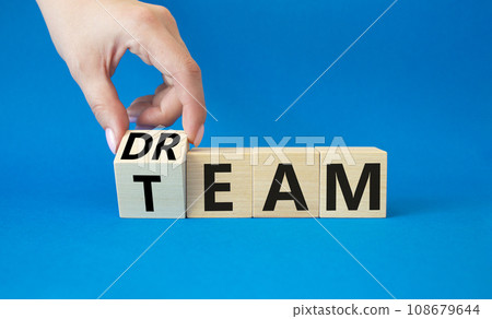 Dream Team symbol. Businessman hand turns wooden cube and changes word Team to Dream. Beautiful blue background. Business and Dream Team concept. Copy space. 108679644