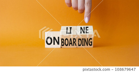 Online Onboarding symbol. Businessman Hand points at turned wooden cubes with words Online Onboarding. Beautiful orange background. Business and Online Onboarding concept. Copy space Online Onboarding symbol. Businessman Hand points at turned wooden cubes with words Online Onboarding. Beautiful orange background. Business and Online Onboarding concept. Copy space 108679647