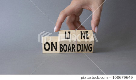 Online Onboarding symbol. Businessman Hand turns cubes with words Online Onboarding. Beautiful grey background. Business and Online Onboarding concept. Copy space 108679649