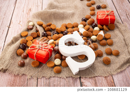 Dutch holiday Sinterklaas background with milk chocolate letter, pepernoten for St. Nicholas Day Dutch holiday Sinterklaas background with milk chocolate letter, pepernoten for St. Nicholas Day 108681129