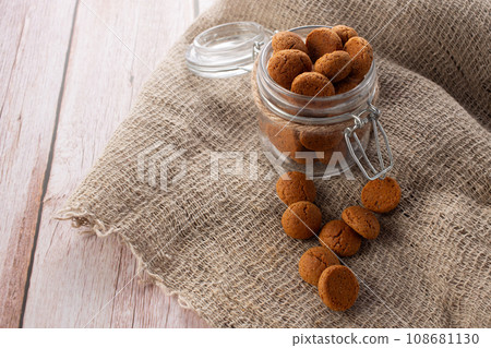 Pepernoten cookies in glass jar on sackcloth. Traditional sweets for St. Nicholas Day 108681130