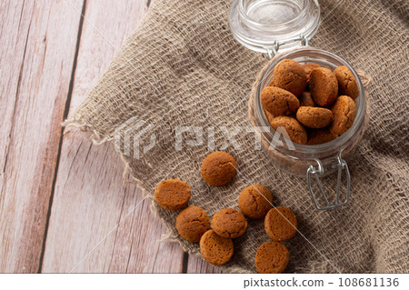 Pepernoten cookies in glass jar on sackcloth. Traditional sweets for St. Nicholas Day 108681136