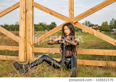 Beautiful young caucasian woman sitting with old rusty machete. Beautiful young caucasian woman sitting with old rusty machete. 108681576
