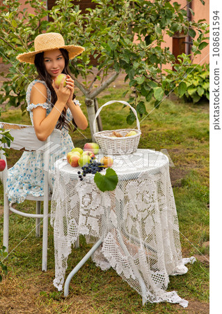 Beautiful young caucasian woman sitting in an orchard. 108681594
