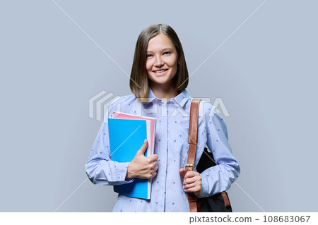Portrait of young university female student on gray background 108683067