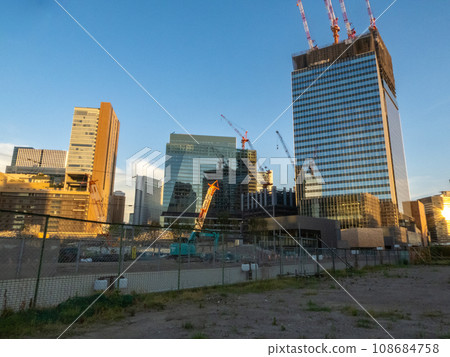 Buildings around Osaka Station under development illuminated by the setting sun 108684758