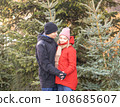 Happy woman and man hugging at Christmas Market in front of Christmas tree. 108685607