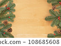 Christmas flat lay of green fir branches, red berries and brown cones on wooden background. 108685608