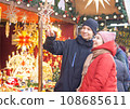Young couple choosing gift for buying and smiling at Christmas market.  108685611