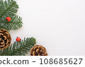 Christmas background of green branches with small red berries and brown cones. 108685627
