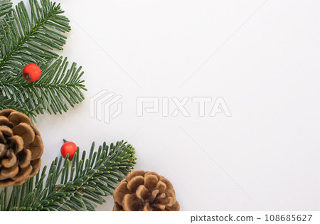 Christmas background of green branches with small red berries and brown cones. Christmas background of green branches with small red berries and brown cones. 108685627