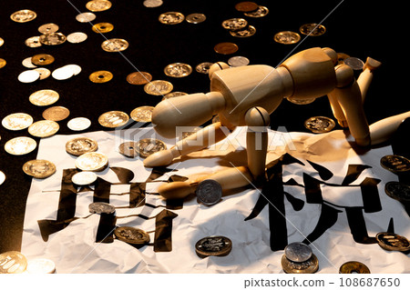 A doll with drooping heads suffering from the tax increase amid scattered coins 108687650