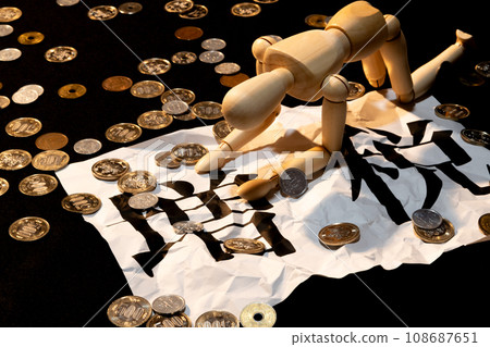 A doll with drooping heads suffering from the tax increase amid scattered coins A doll with drooping heads suffering from the tax increase amid scattered coins 108687651