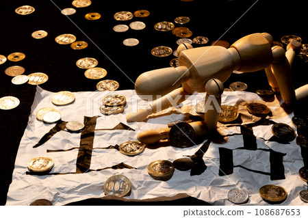 A doll with drooping heads struggling to survive among scattered coins 108687653