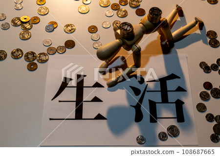 A doll with drooping heads struggling to survive among scattered coins 108687665