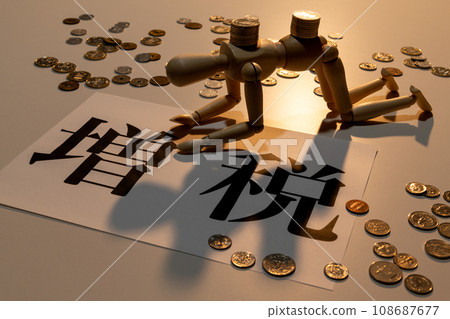 A doll with drooping heads suffering from the tax increase amid scattered coins 108687677