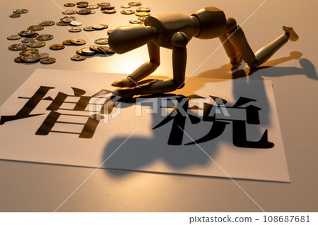 A doll with drooping heads suffering from the tax increase amid scattered coins 108687681