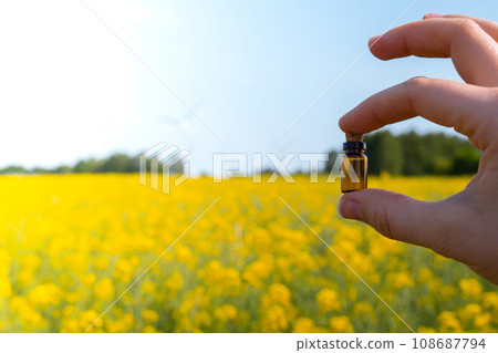 Hand holding test tube with liquid on background of canola flowers field blooming farm. Rapeseed oil over natural background. Farmer soil sample in tube chemical analysis ph test. Agrochemical Hand holding test tube with liquid on background of canola flowers field blooming farm. Rapeseed oil over natural background. Farmer soil sample in tube chemical analysis ph test. Agrochemical 108687794